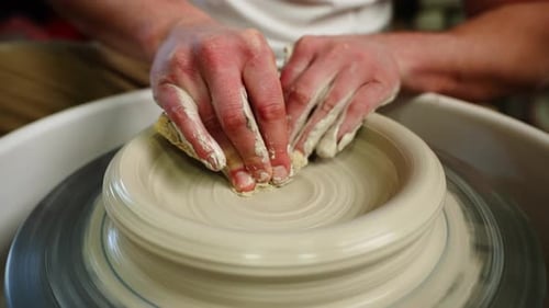 Crop of Unknown Man Artisan in Pottery Workshop Making Clay Pot on Rotary Machine