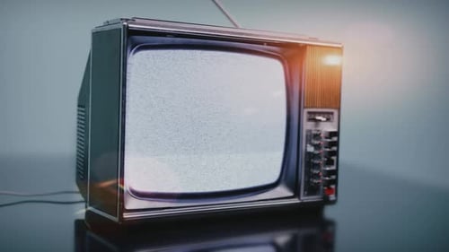 Vintage Television Displaying Static on Reflective Surface