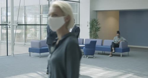 Business people in office meeting in lobby wearing protective face mask and using digital tablet