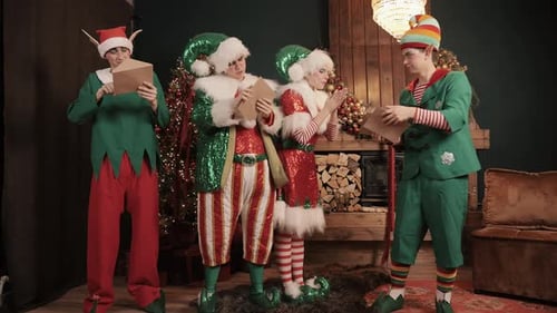 Festive Elves Reading Letters near Fireplace at Christmas