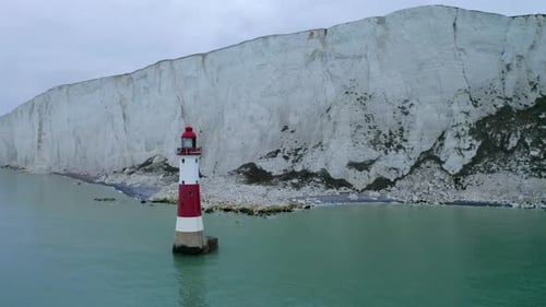 Eine kreisende Luftaufnahme rund um den Leuchtturm Beachy Head in East Sussex mit den hohen weißen Kreidefelsen