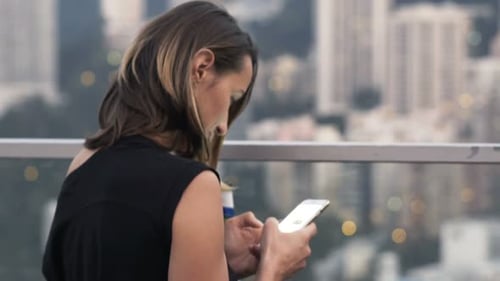 Young Beautiful Woman Texting on Smartphone at Luxury Bar 30s