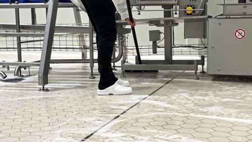 Low Angle View of Worker Scrubbing Industrial Floor