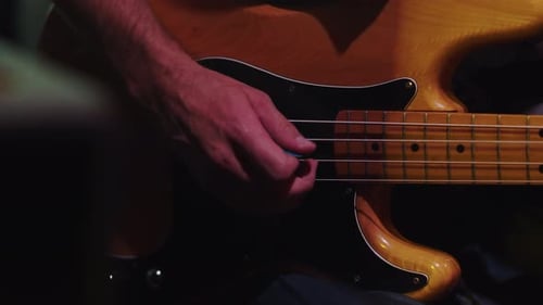 Musician Playing Bass Guitar Notes with Fingers