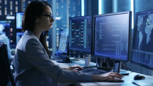 Woman Typing on Computer in Data Control Center