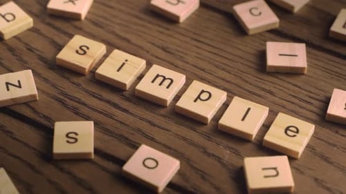 La main place des carreaux en bois sur une table en bois pour une orthographe simple