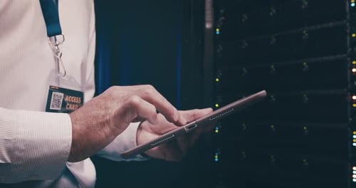 Adult Using Tablet in Dark Server Room
