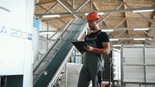Adult Worker with Clipboard at Factory Workplace