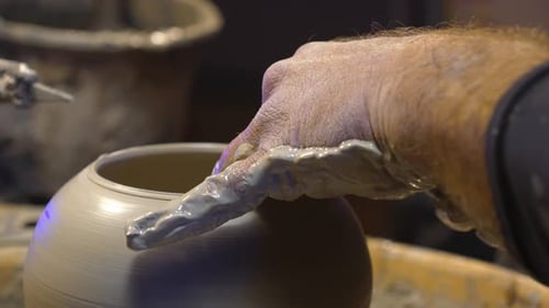 Potter Shaping Clay on Wheel in Studio