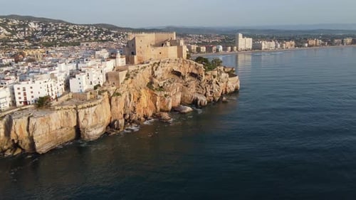 The Peniscola Castle and village on a crag overlooking the Mediterranean Sea - aerial flyover