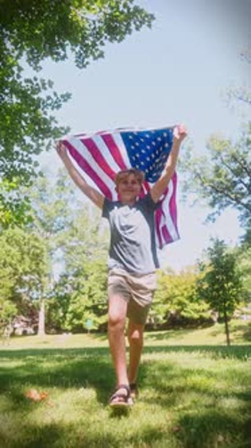 Boy Runs with American Flag in Sunny Field