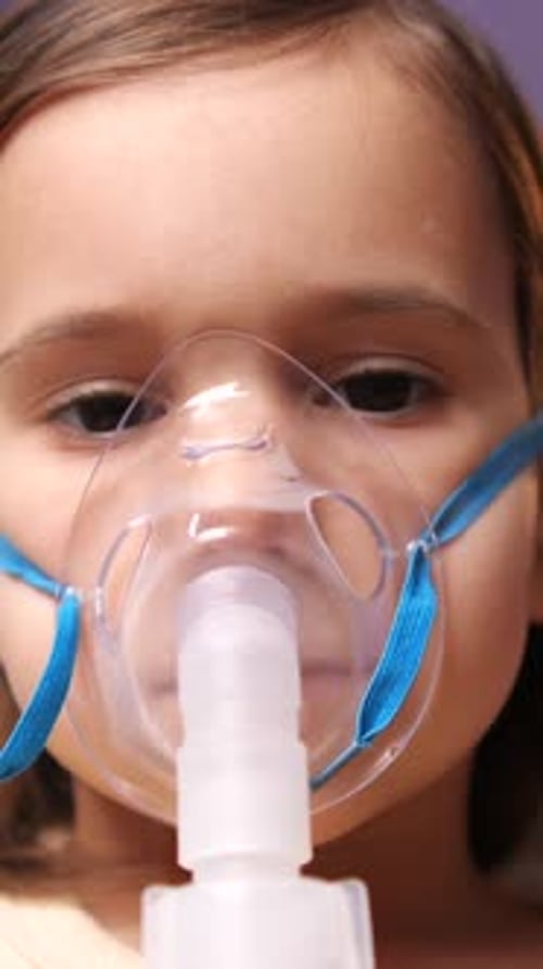 Child Wearing Oxygen Mask and Nebulizer Close Up