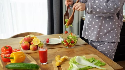 Person Making Healthy Salad in Bright Kitchen