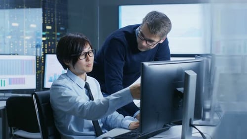 In the Data Mining Center Chief Statistician Consults His Young Assistant sits at His Workstation S