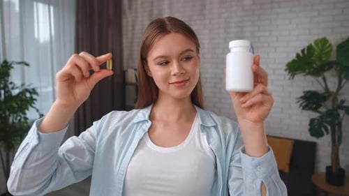 Woman Holding Bottle and Vitamin Capsule Smiling