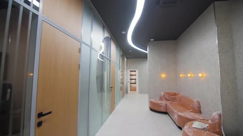 Foiled Sofas in Corridor with Glass Office Walls in Building