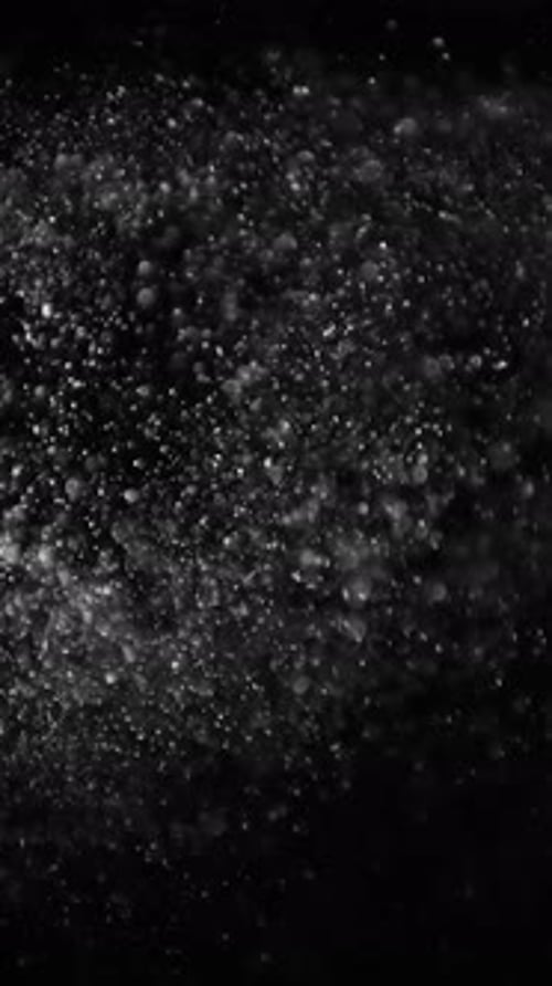 Rising White Dust Particles on Black Background Slow Motion
