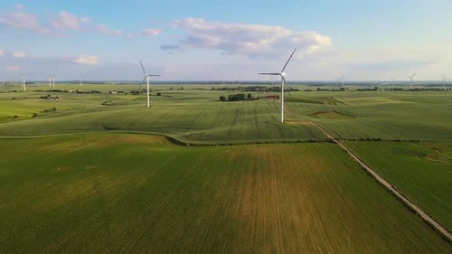 Wind Turbines Turning in Open Green Farmland