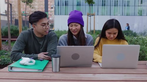 Three Young Asian Student Friends Studying Together on Table College Campus