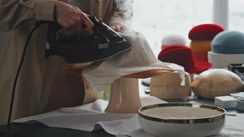 Hat Maker Ironing Brim of Hat in Workshop