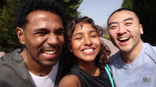 Gruppe von drei verschiedenen Freunden, die zusammen lächeln, lachen und Spaß haben, während sie ein Selfie-Video machen