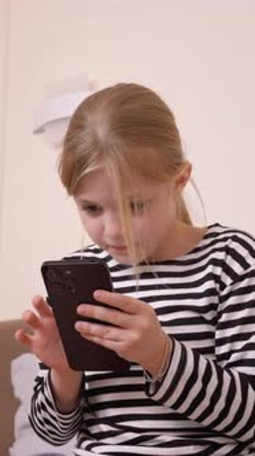 Girl uses smartphone in indoor setting, close-up