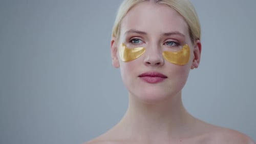 Woman Smiling With Gold Eye Patches On