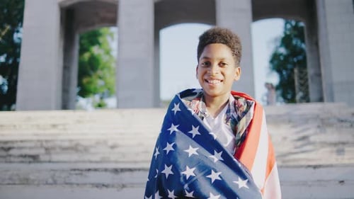Smiling Boy Holding American Flag Outdoors