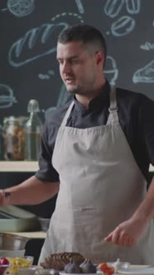 Der Koch stellt die Pfanne auf den Herd und wirft Brot hinein, während er den Food-Vlog dreht