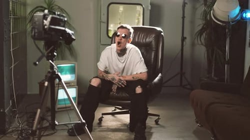 Man Sitting in a Chair Speaking to Camera