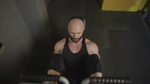 A Man Does a Leg Press on the Exercise Machine in the Gym
