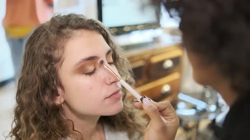 Client with Her Eyes Closed While a Makeup Artist Applies Eye Shadow