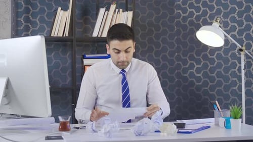 Unmotivated Tired businessman crumpled papers and throws them away.