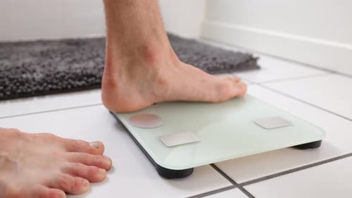 Man Checking Weight Bathroom Scale
