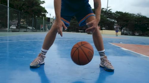 close-up of a basketball player playing with a ball outdoors