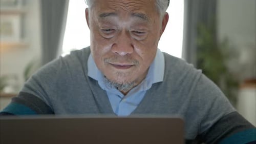 Older Man Stretching After Using Laptop at Home