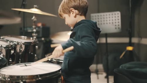 Young Boy Plays Drums in Music Studio