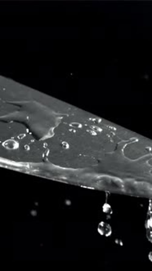Drops of Water Fall on the Knife Blade Filmed on a Highspeed Camera at 1000 Fps
