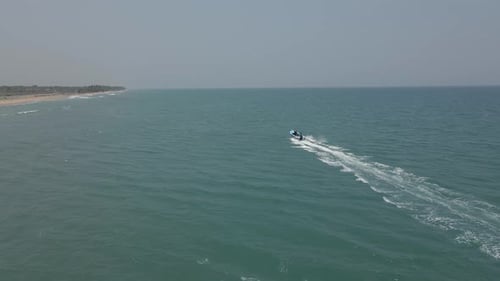Jet Ski Speeding Through Open Water Near Shoreline