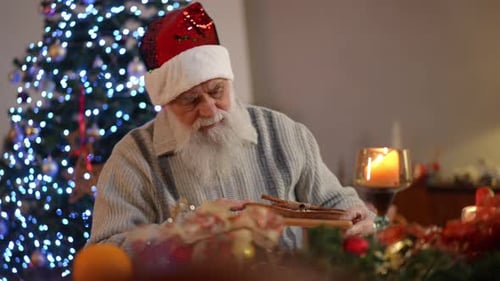 Elderly Man in Santa Hat Smelling Christmas Food