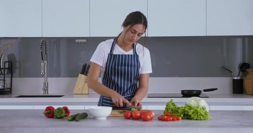 Woman Cutting Vegetables in Modern Kitchen