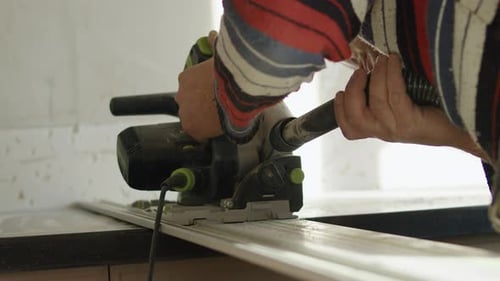 Worker Using Power Saw to Cut Kitchen Countertop