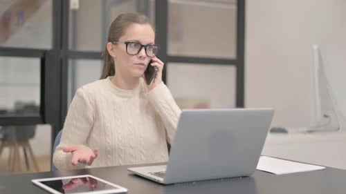 Woman Talking on Cellphone in Bright Office Setting