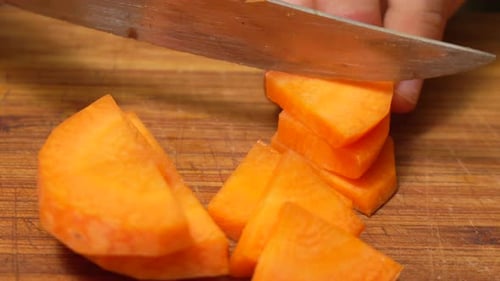 Close Up of Chopping Carrot on Wooden Board