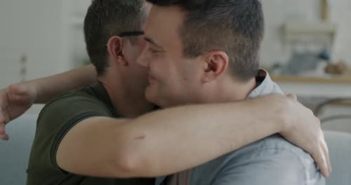Affectionate Men Embrace Tenderly in Home Setting