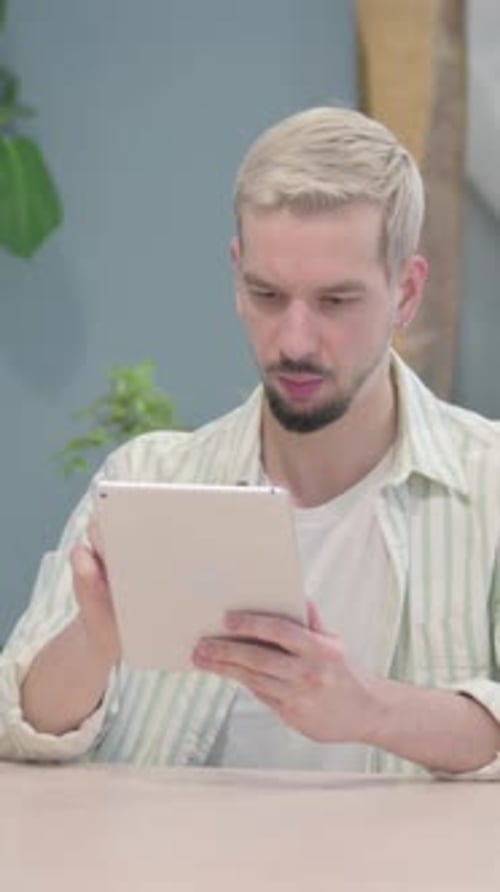 Man With Light Hair Uses Tablet Indoors