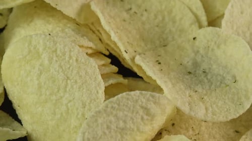 Close up potato chips spinning background. Snack for drinks. Golden fried potatoes. Crispy snacks