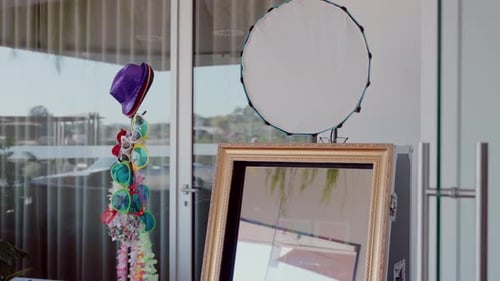 Photo booth setup with a decorative mirror, colorful props, and party accessories