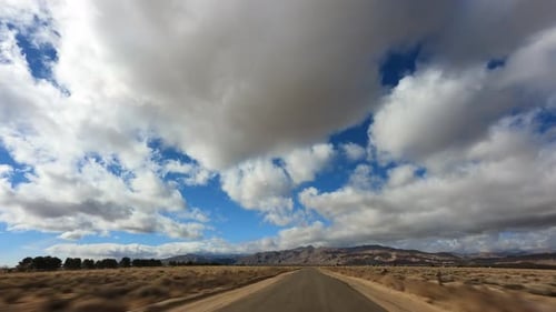 Driving through the Mojave Desert with a dramatic cloudscape overhead - hyper lapse