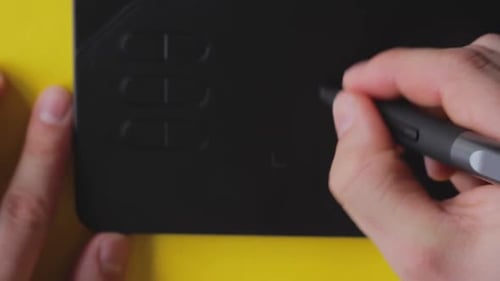 Hands Using Stylus on Graphics Tablet